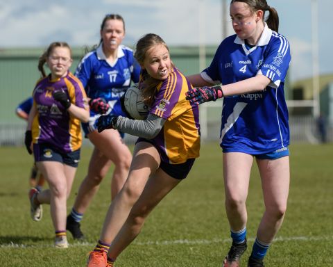 Kilmacud player shielding the ball from a tackle