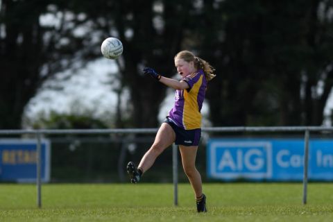 Kilmacud player kicks the ball away with her right foot