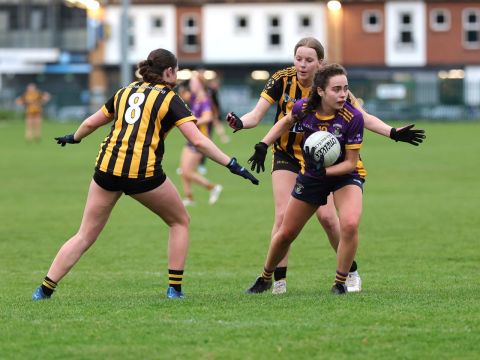 Kilmacud no 10 passes the ball away under pressure