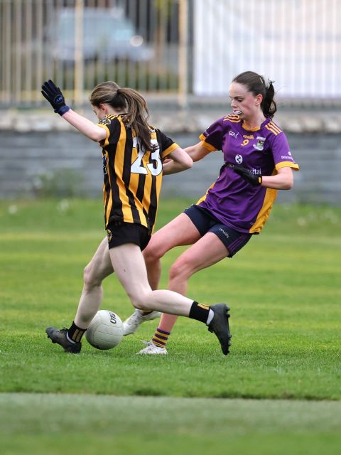 Two players, including Kilmacud no 9, use their feet to try win the ball from each other